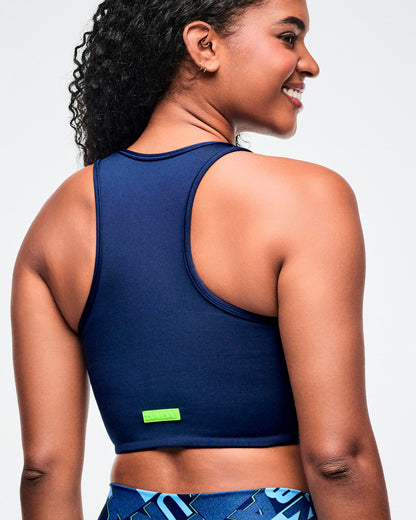 Female model wearing a solid blue sports bra viewed from the back.