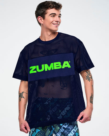 Male model wearing an indigo Zumba mesh top with “Zumba” in green text.