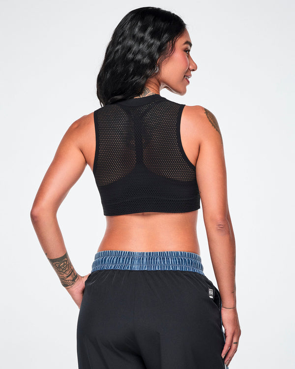 Back view of a female model wearing the black double-layer mesh Dale-Z crop bra with removable cups, paired with denim pants featuring a solid black back panel.