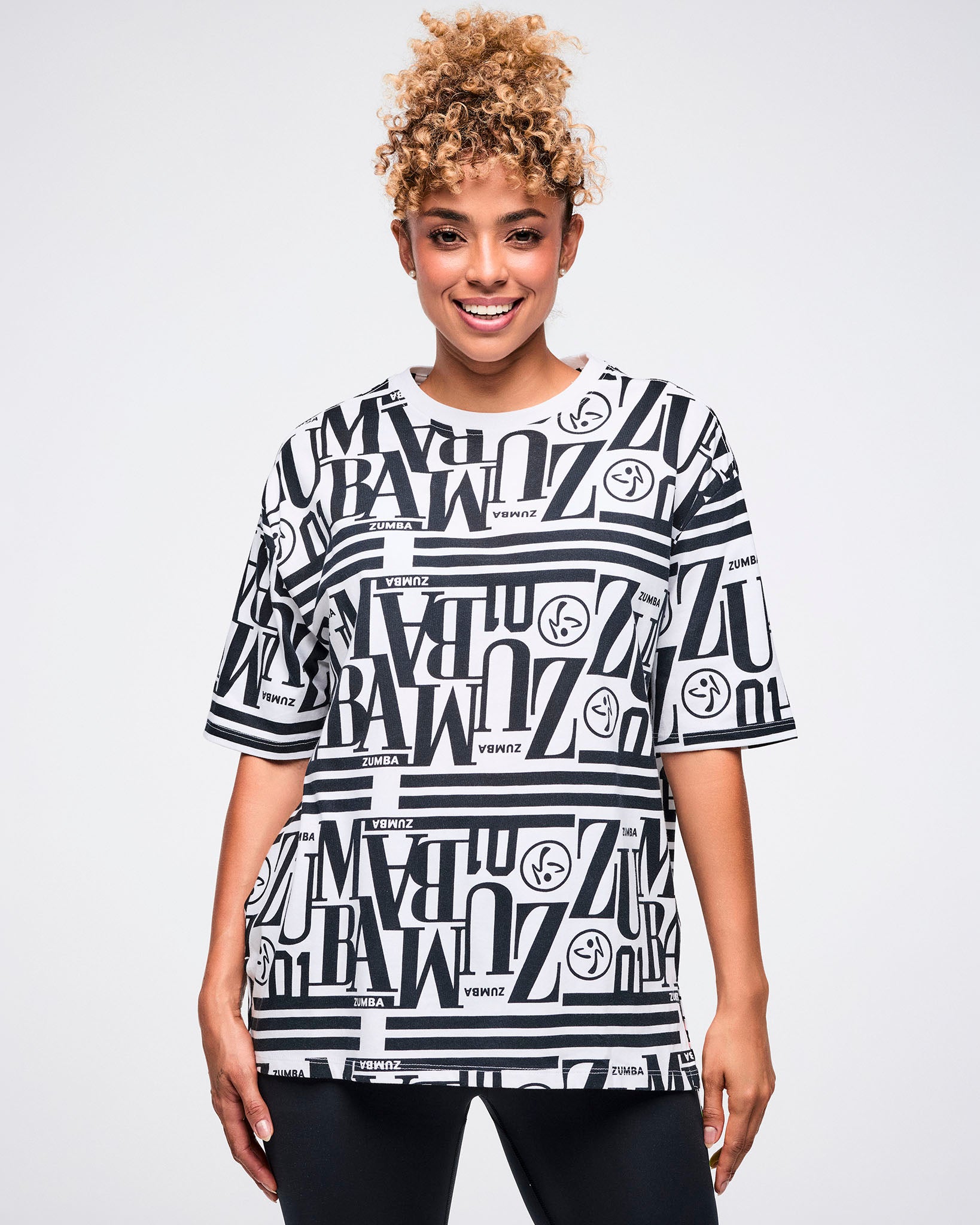 Female model wearing a black and white patterned Zumba boxy top.