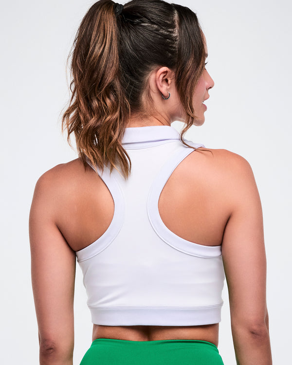 Back view of a female model wearing a white Zumba racerback polo.