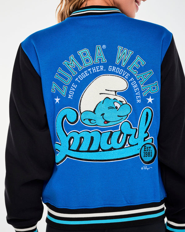Close-up from behind of the blue and black varsity jacket’s back graphic, showing the winking Smurf, the looping chenille script ‘Smurf,’ white embroidered stars, and a small ‘© Peyo’ signature.