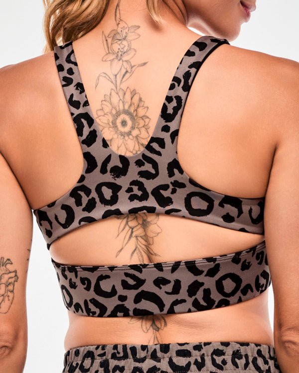 Close-up back view of a brown leopard print longline bra, showing the racerback straps and keyhole cutout above the wide underband.