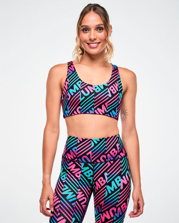 Female model wearing a sports bra with a pink, aqua, and black diagonal 