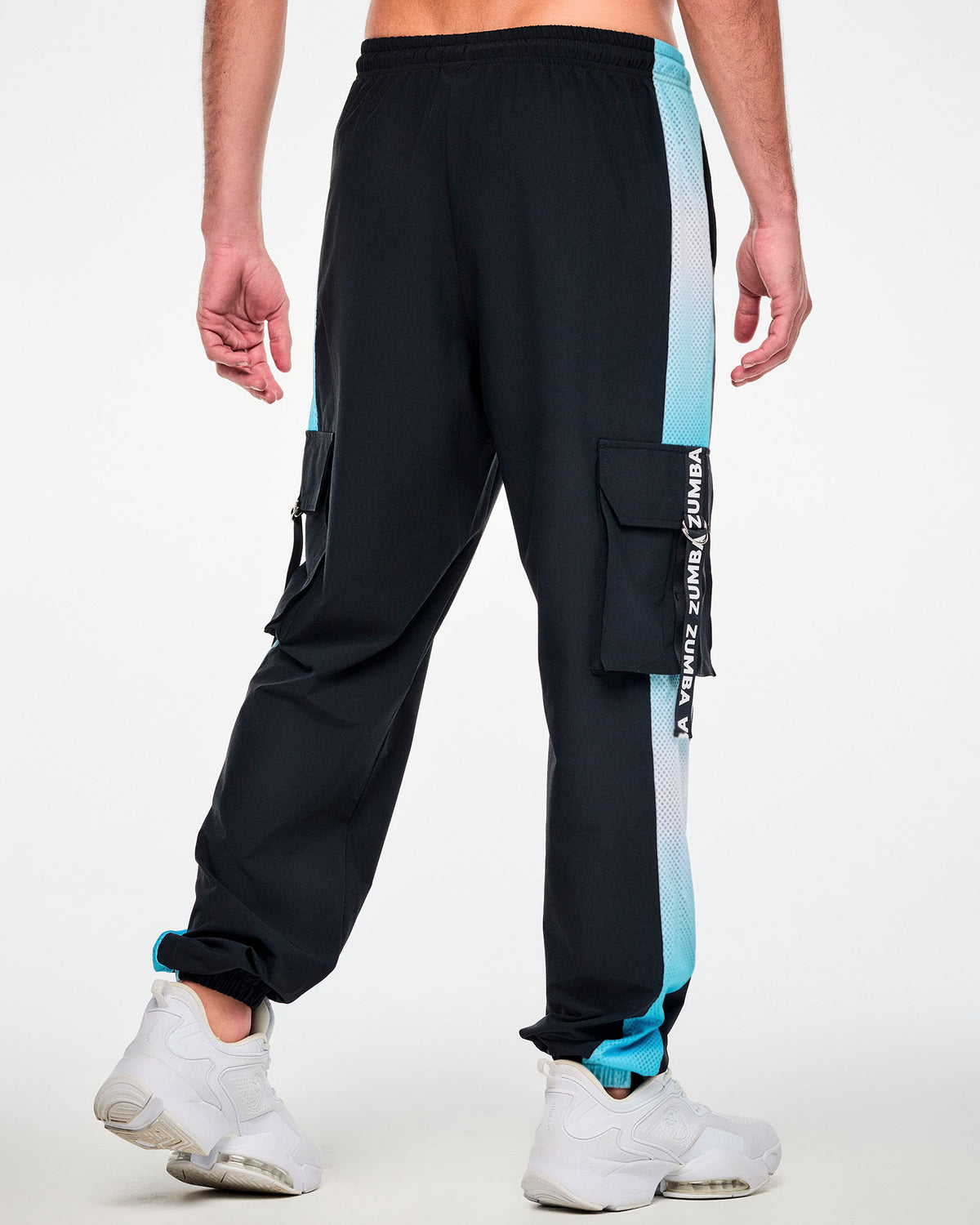 Shown from the back, a male model in the black cargo pants, with a cargo pocket on each leg and the light blue ombre mesh side panels running down to the cuffs.