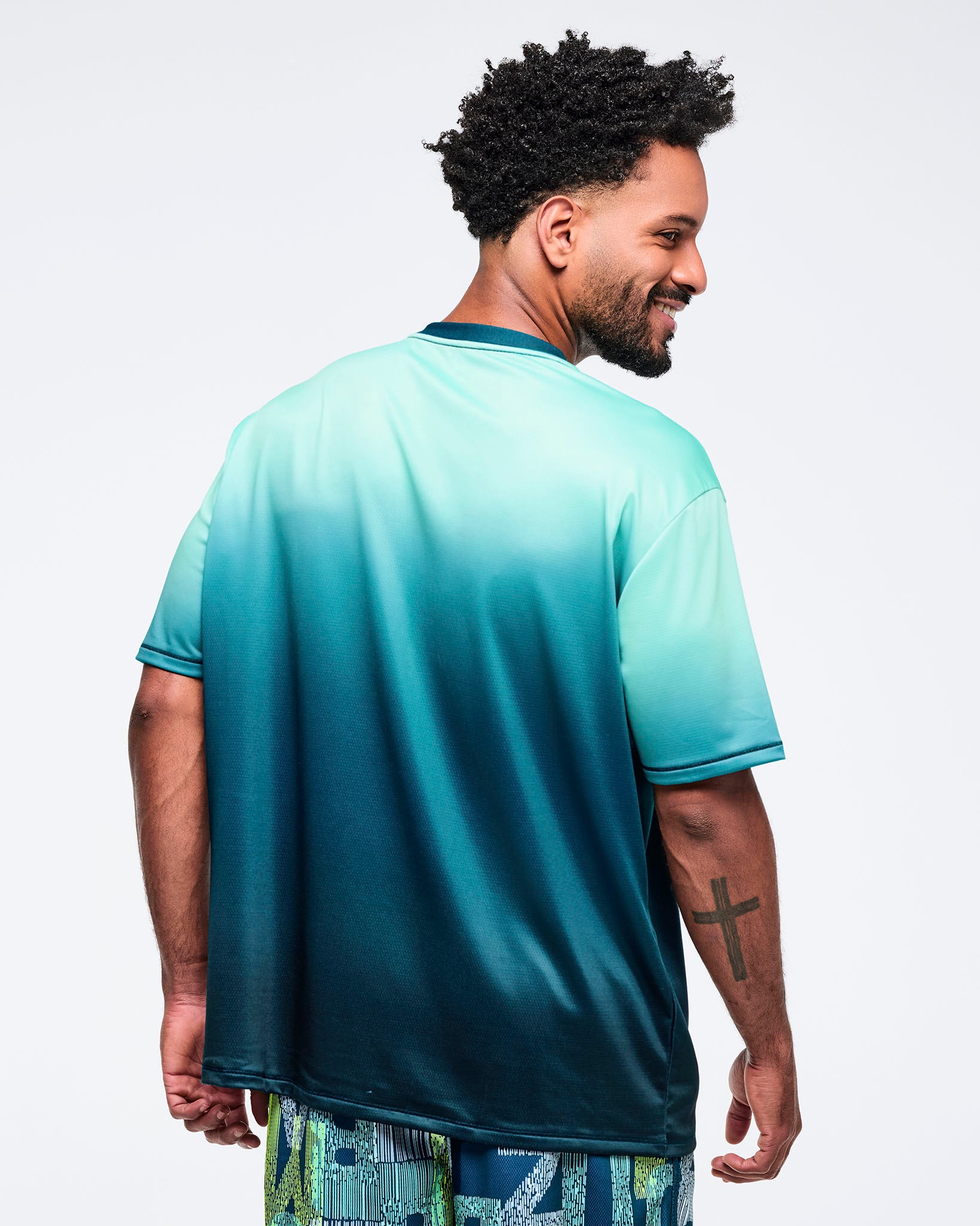 Ombre aqua-to-deep teal short-sleeve T-shirt with dark ribbed crewneck and sleeve trim, shown from the back on a male model; relaxed fit with clean, solid gradient.