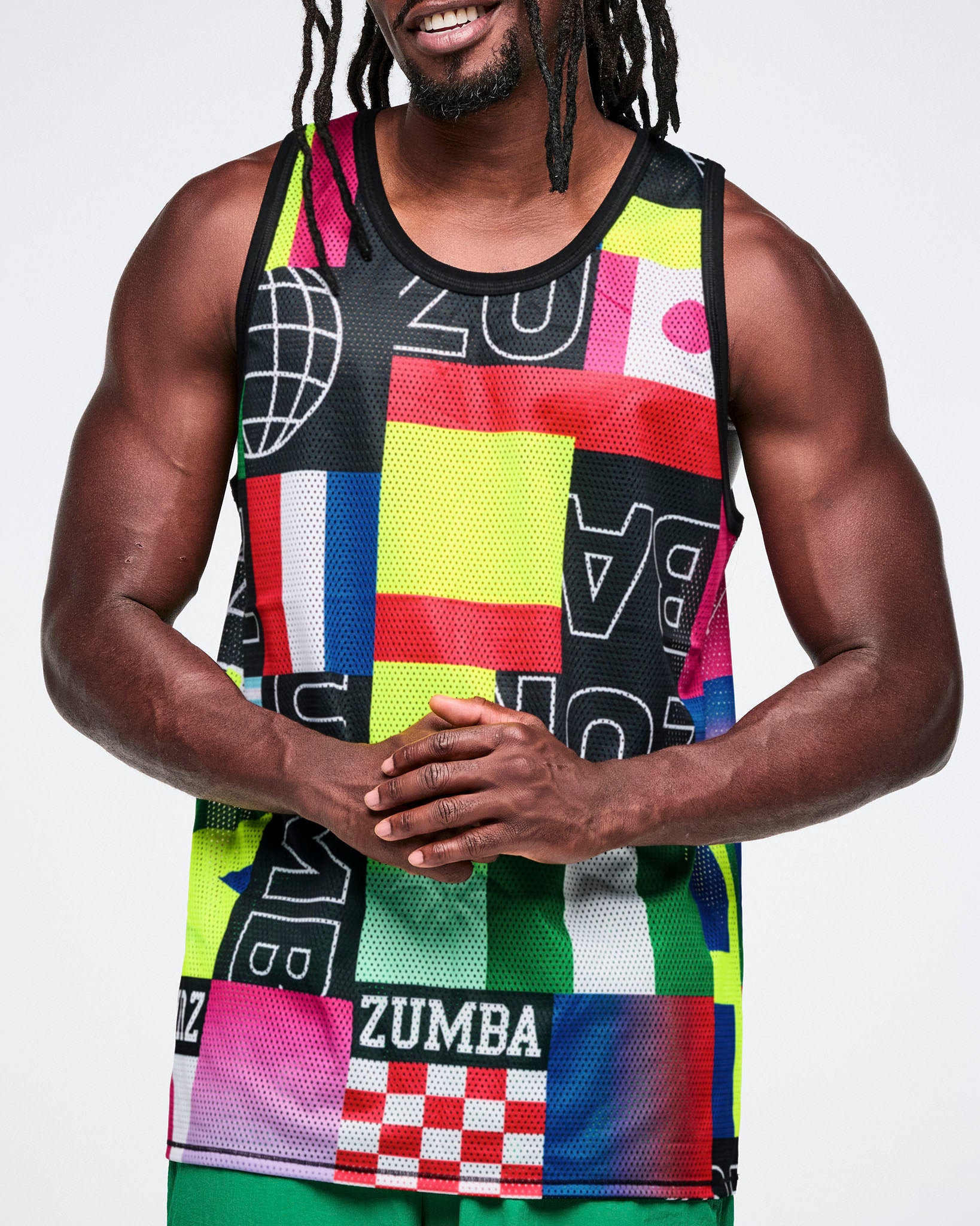 Close up of a male model wearing a colorful Zumba tank top with geometric patterns on a white background.