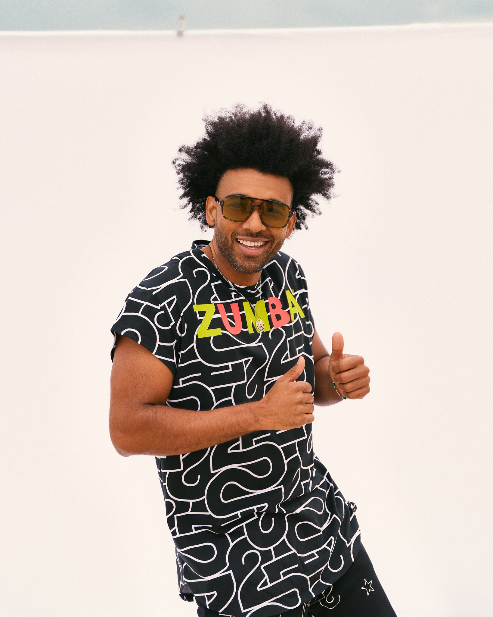 Male model wears the loose black short-sleeve tee with black jogger pants, posing in front of a white backdrop.