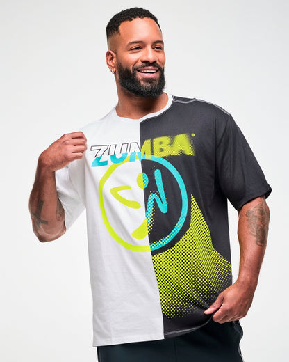 Male model wearing a black and white colorblock oversized T-shirt with a yellow and aqua "ZUMBA" text and Zumbito graphic in the middle.