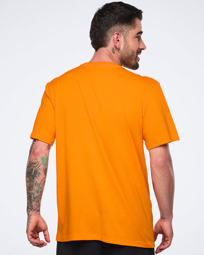 Male model shown from the back wearing an oversized bright orange short-sleeve T-shirt with a relaxed fit, paired with black bottoms.