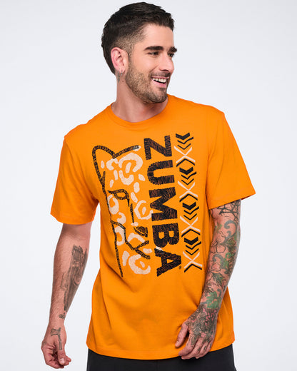 Male model wearing a bright orange short-sleeve Zumba T-shirt with a large black-and-white vertical graphic, abstract animal face artwork, and black bottoms.