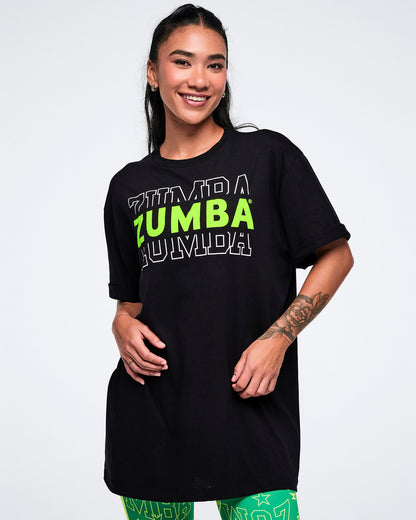 Female model wearing a black Zumba t-shirt with green text on a white background.