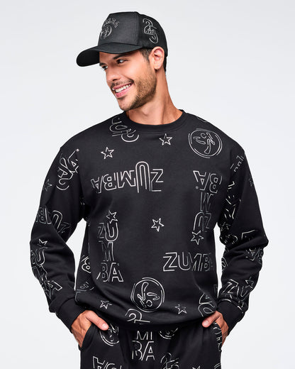Black baseball cap with silver Zumba logo on the front and a silver 25 Years graphic on the side. A smiling male model wears the cap with a black crewneck sweatshirt covered in silver Zumba graphics and matching black joggers against a light gray background.