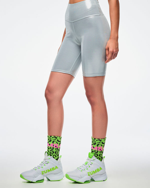 Female model wearing green leopard print socks with matching green and white shoes paired with silver biker shorts.