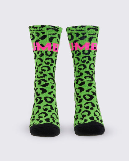 A pair of high socks, from the front, featuring a bright green and black leopard print pattern, with a pink 'ZUMBA' text on the top and solid black toes and heels, shown against a white background.