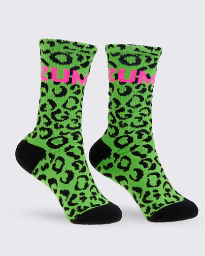 A pair of high socks featuring a bright green and black leopard print pattern, with a pink 'ZUMBA' text on the top and solid black toes and heels, shown against a white background.