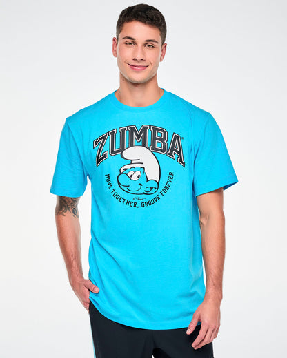 Male model in a blue crew neck tee with arched black varsity 'ZUMBA' text over a large smiling Smurf face in a white hat, framed by curved 'MOVE TOGETHER, GROOVE FOREVER' text. Paired with black pants.