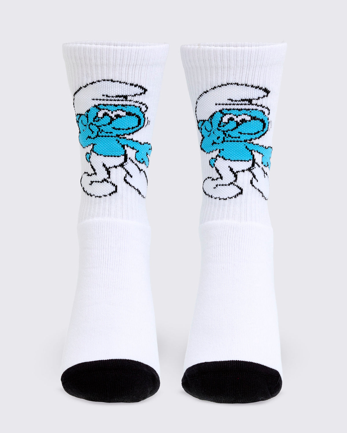 White ribbed crew socks with black heels and toes, each with a knit Smurf dancing on the front above a plain white foot.