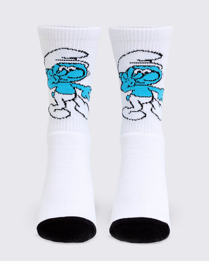 White ribbed crew socks with black heels and toes, each with a knit Smurf dancing on the front above a plain white foot.