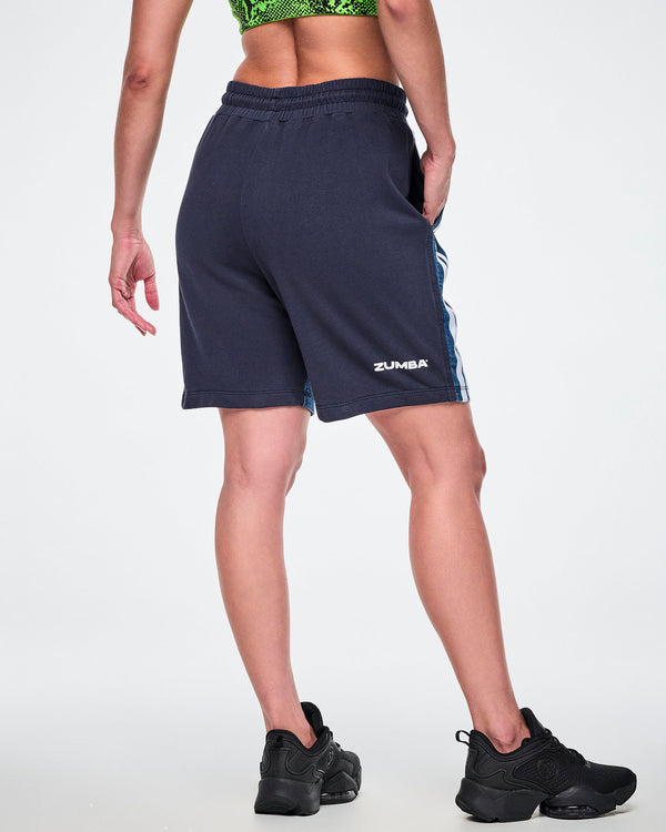 Back view of a female model wearing navy combo shorts with white 