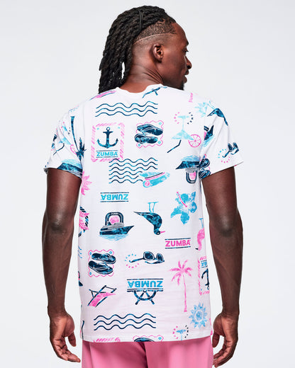 Back view of a white short-sleeve crewneck Zumba graphic tee featuring a teal-and-pink allover nautical and tropical print; shown on a male model with pink pants.