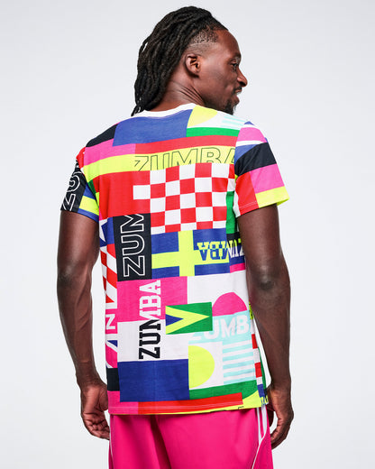 Back view of a male model wearing a colorful Zumba shirt with flag patterns on a white background.
