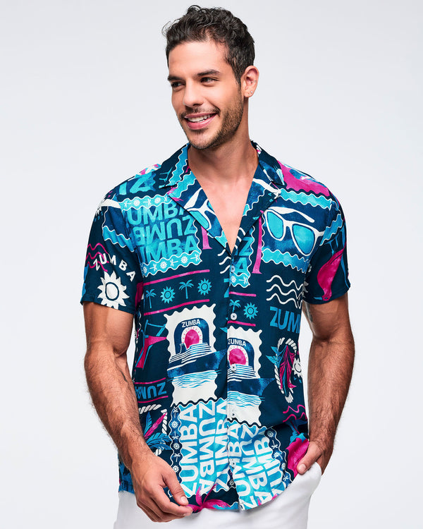 Navy short-sleeve button-up shirt with a relaxed collar and bold teal, white, and hot pink Zumba tropical graphic print throughout; shown on a male model with white shorts.