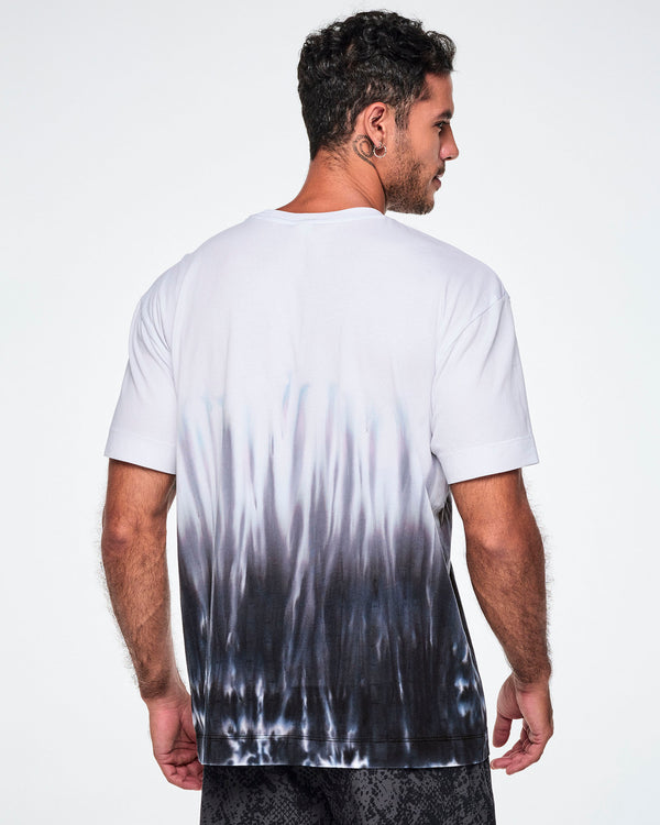 Back view of a male model wearing a white tee with a black-to-white tie-dye flame pattern at the bottom, posed against a white background.