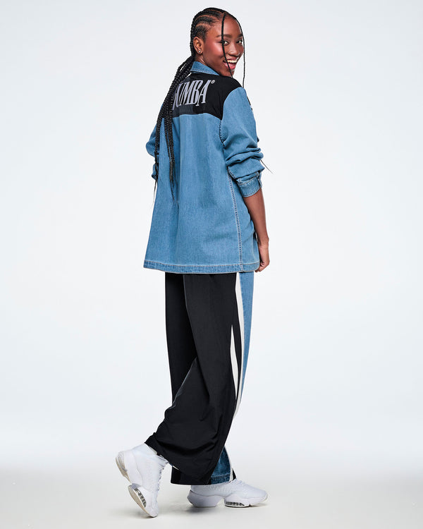 Side view of a female model walking in a denim shacket, showing the black yoke with white 