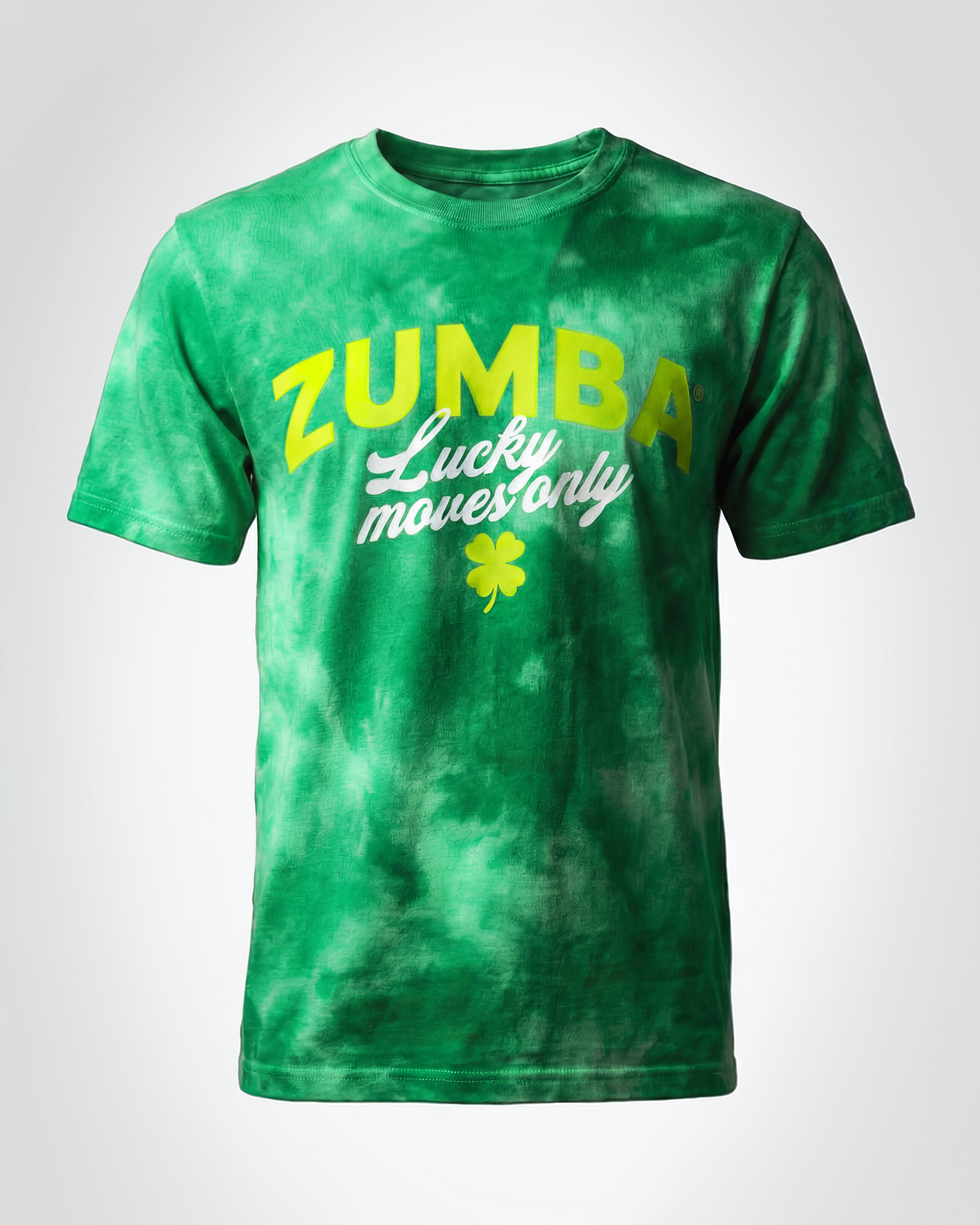 Green tie-dye short-sleeve crewneck T-shirt with large yellow “ZUMBA” lettering, white script “Lucky moves only,” and a small shamrock graphic centered on the chest.